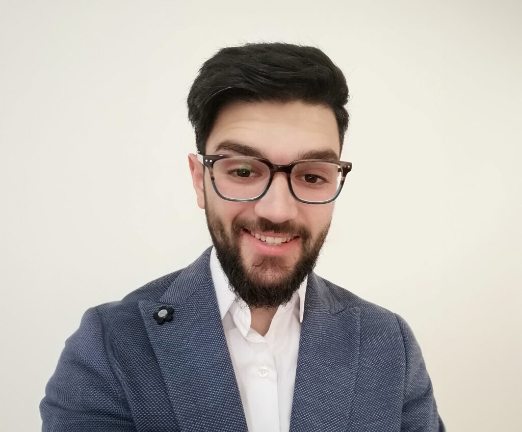 Headshot of Momen Muhanned wearing a textured blazer